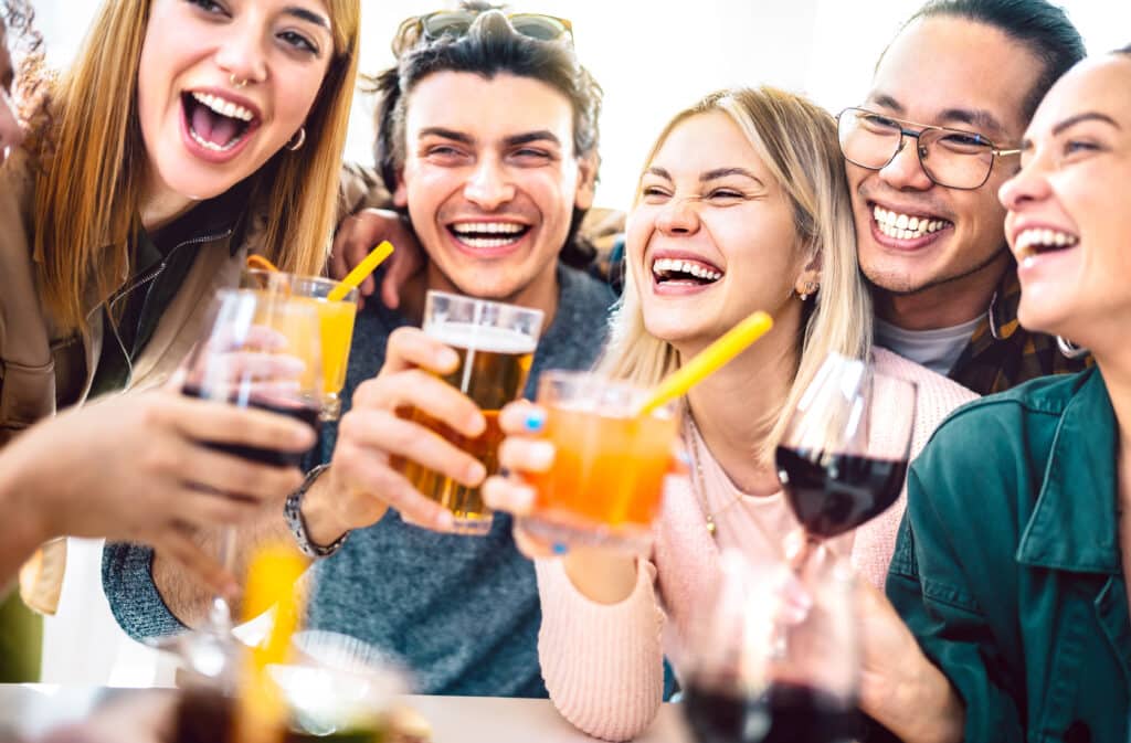 Young people having fun together drinking beer and wine at happy hour