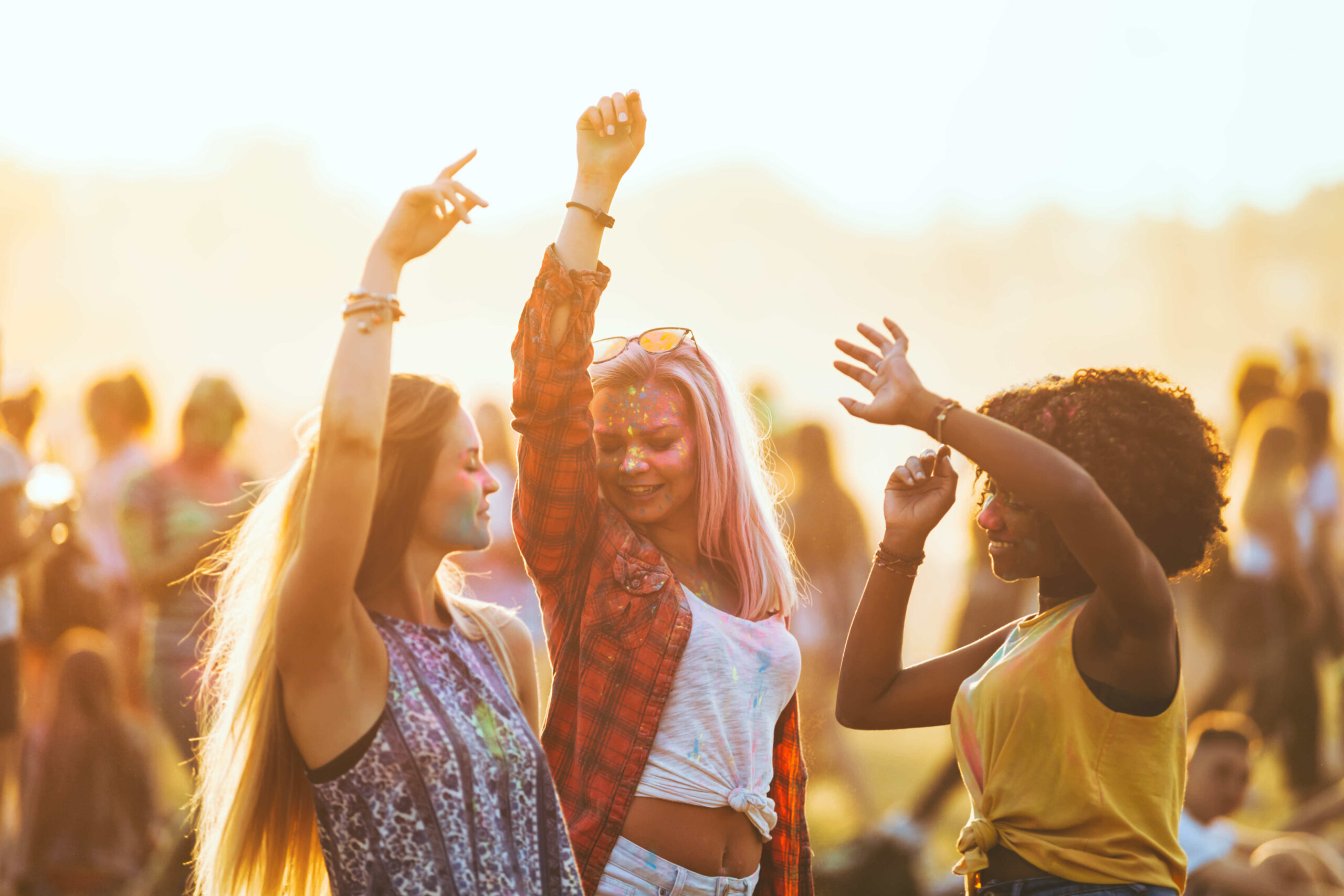 Three girls dancing at a music festival