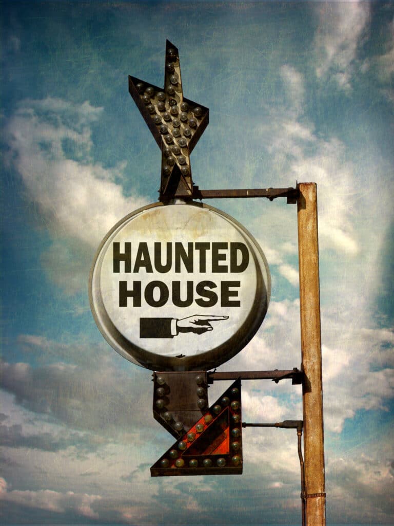 Haunted house marketing sign pointing in direction of the venue 