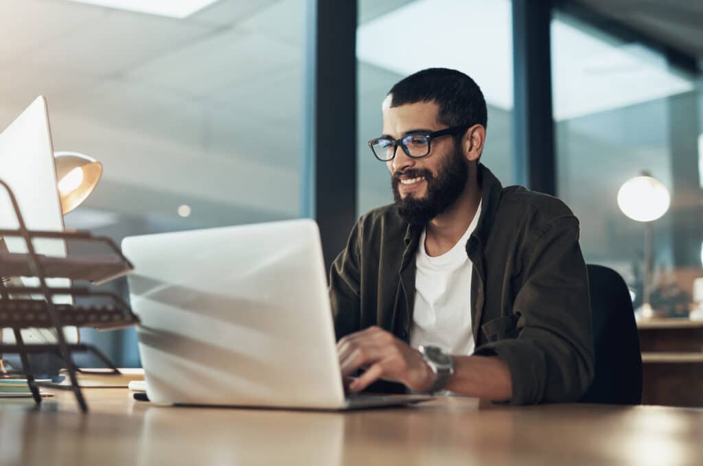 business man with laptop sending email communications and reviewing ticket sales 